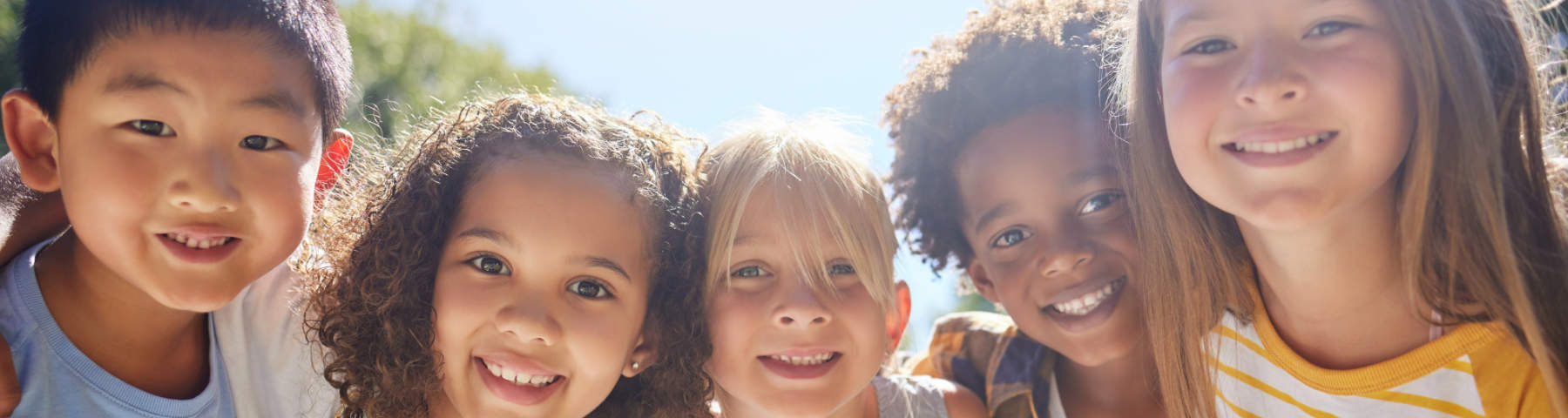 Group of diverse children smiling outdoors.
