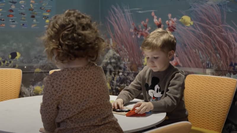 Roger and his sister playing at a table.
